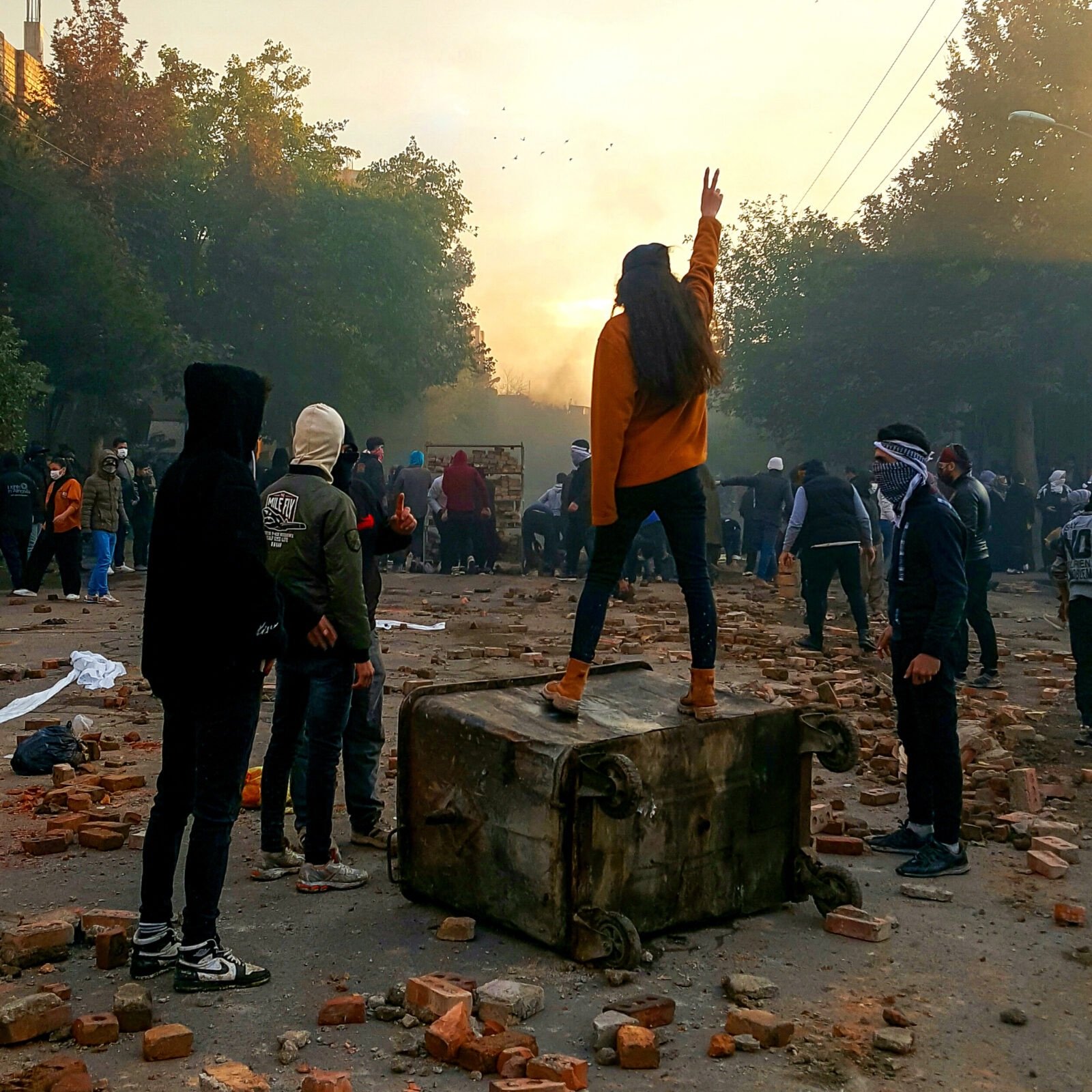 11/17/2022 Bukan, Iran. A young woman without wearing a hijab flashes a victory sign while standing on a dumpster during a protest.
The nationwide protests started after the death of Mahsa Amini, a 22-year-old girl who died under the custody of the Islamic Republic's Morality Police on September 16th, 2022 in Tehran, Iran. (Photo by Anonymous / Middle East Images / Middle East Images via AFP)