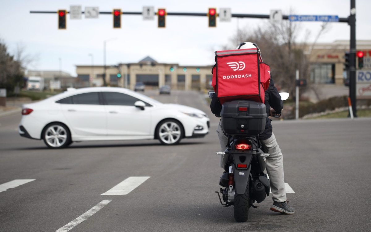 A food delivery rider waits for the traffic light to change to head northbound on Chester Street at County Line Road as a statewide stay-at-home order remains in effect in an effort to reduce the spread of the new coronavirus Monday, March 30, 2020, in Lone Tree, Colo. The new coronavirus causes mild or moderate symptoms for most people, but for some, especially older adults and people with existing health problems, it can cause more severe illness or death. (AP Photo/David Zalubowski)