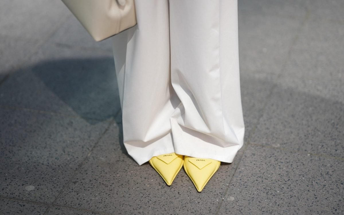 FRANKFURT AM MAIN, GERMANY - MAY 12: Angelika Hanel is seen wearing a Limited Edition white pleated wide legsuit pants from Massimo Dutti, a T-Lock leather handbag in milk white from Toteme, a pair of yellow slingback pointed kitten-heels with triangle shaped logo detail from Prada on May 12, 2025 in Frankfurt am Main, Germany. (Photo by Moritz Scholz/Getty Images)
